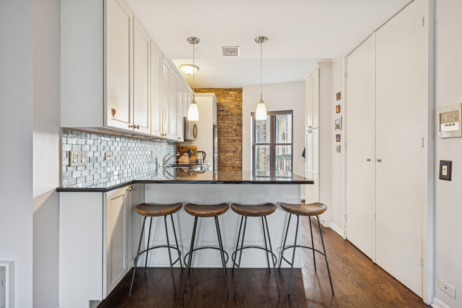 815 West Cuyler Avenue, Unit 3 Chicago, IL 60613 - Photo 5 of 16 a kitchen with stainless steel appliances granite countertop a table chairs in it and wooden floors