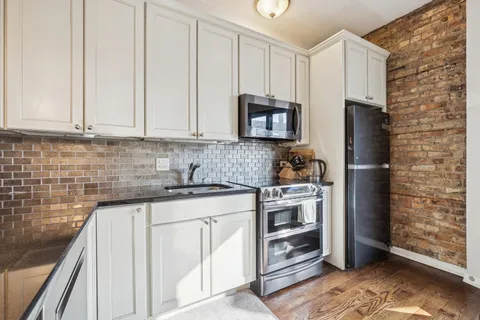 a kitchen with stainless steel appliances granite countertop a stove a refrigerator and a cabinets