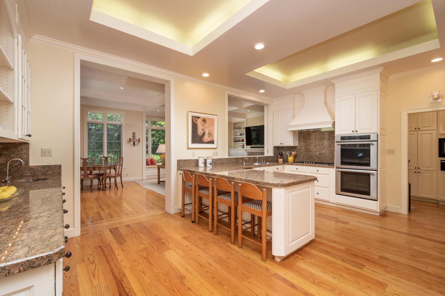 720 Eucalyptus Avenue Hillsborough, CA 94010 - Photo 18 of 48 a large kitchen with stainless steel appliances kitchen island granite countertop a large counter top and view of living room