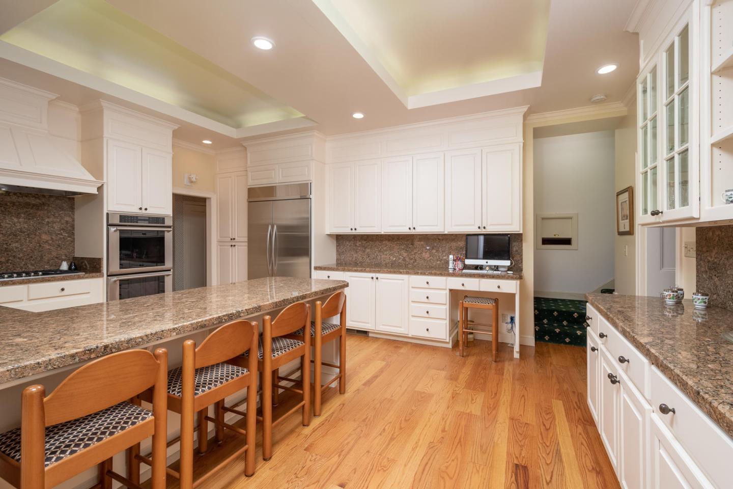 720 Eucalyptus Avenue Hillsborough, CA 94010 - Photo 19 of 48 a large kitchen with granite countertop lots of counter space and stainless steel appliances