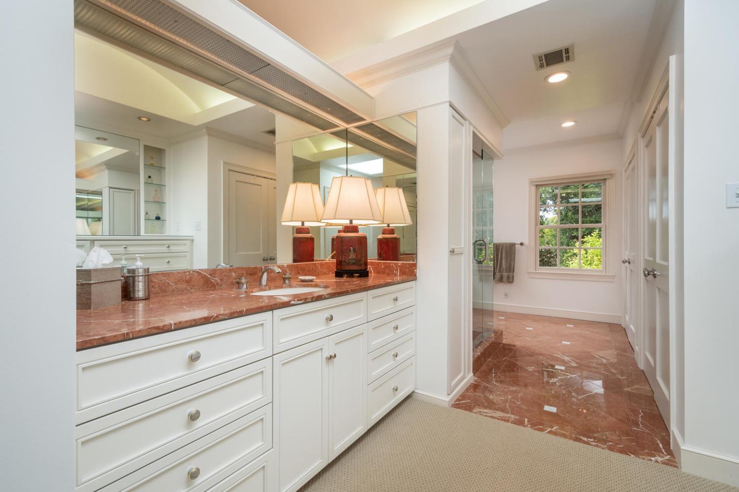 720 Eucalyptus Avenue Hillsborough, CA 94010 - Photo 30 of 48 a spacious bathroom with a shower a sink and mirror