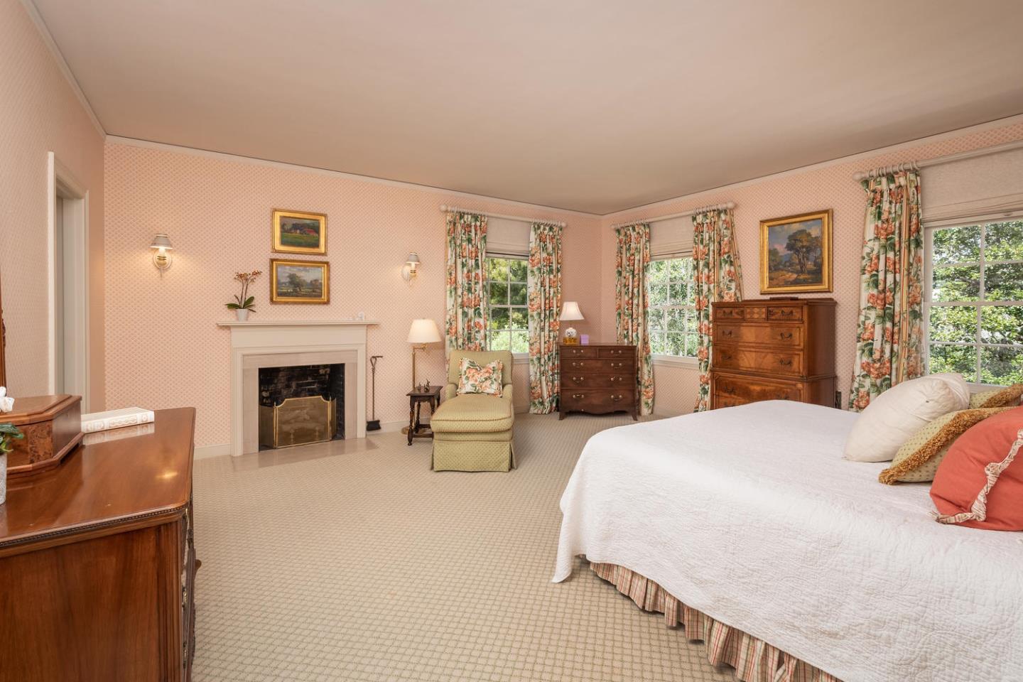 720 Eucalyptus Avenue Hillsborough, CA 94010 - Photo 31 of 48 a spacious bedroom with a bed and a fireplace