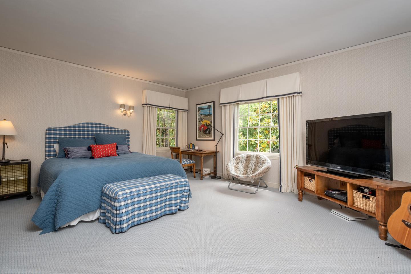 720 Eucalyptus Avenue Hillsborough, CA 94010 - Photo 36 of 48 a bedroom with a bed and flat tv screen on the dresser