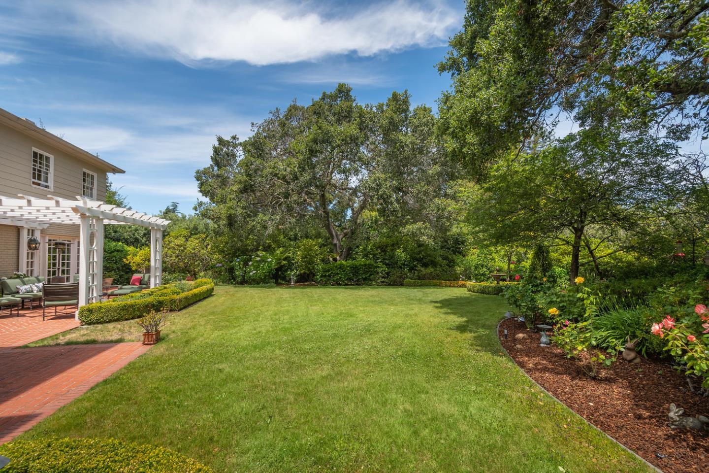 720 Eucalyptus Avenue Hillsborough, CA 94010 - Photo 43 of 48 a view of a yard with plants and large trees