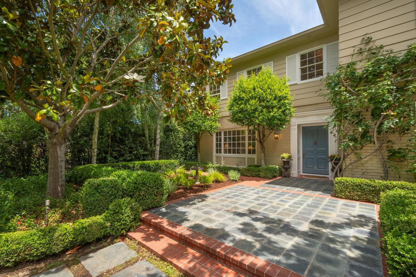 720 Eucalyptus Avenue Hillsborough, CA 94010 - Photo 6 of 48 a front view of a house with a yard and potted plants