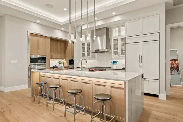 a kitchen with kitchen island granite countertop a sink cabinets and stainless steel appliances