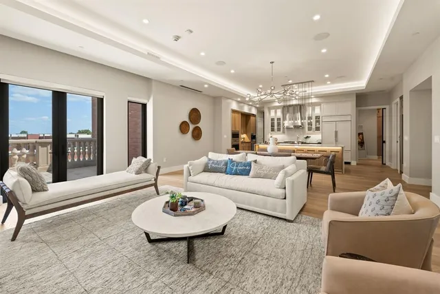 a living room with furniture and a dining table with kitchen view