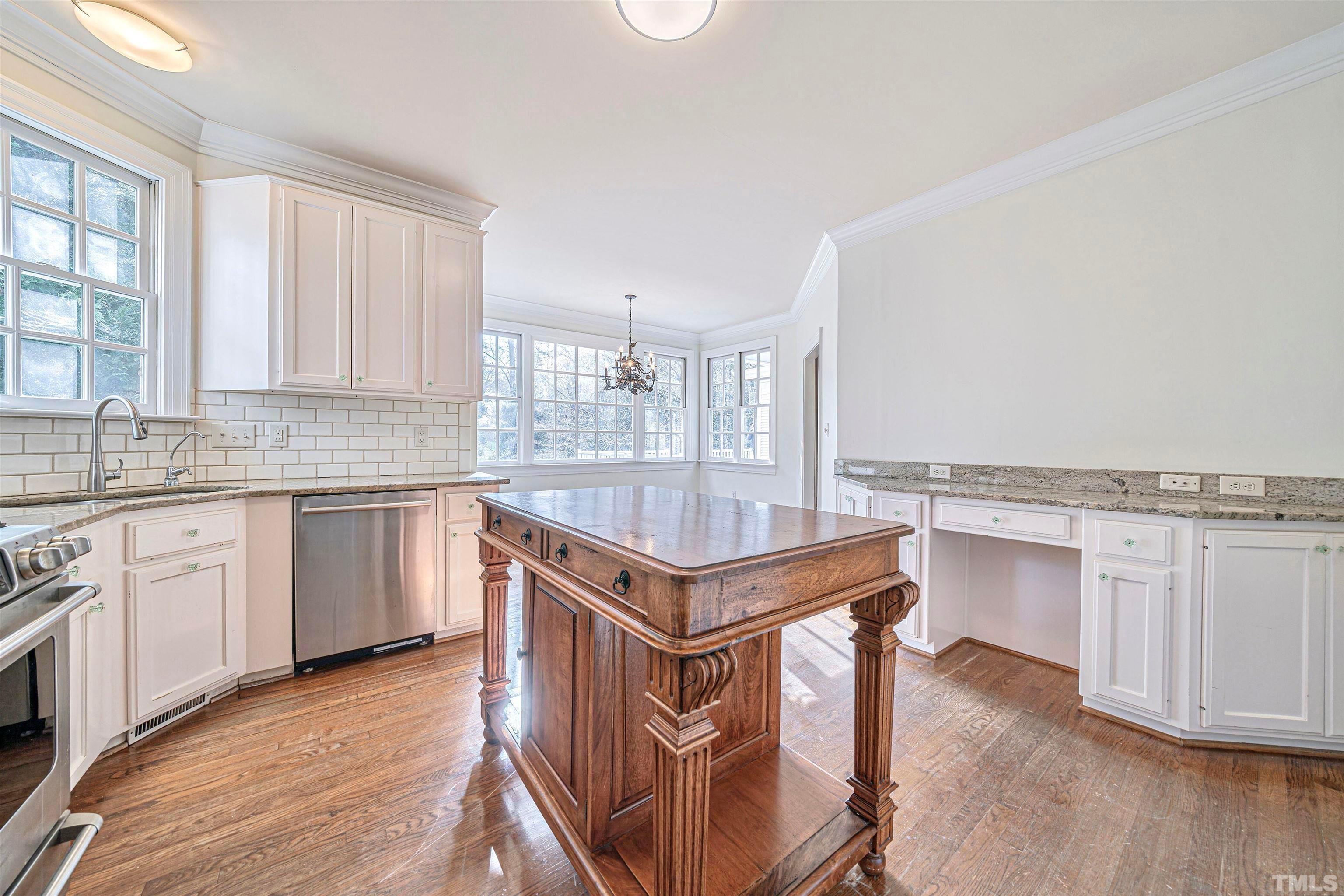 709 Runnymede Road Raleigh, NC 27607 - Photo 23 of 50 a kitchen with stainless steel appliances granite countertop a stove top oven a sink dishwasher and white cabinets with wooden floor