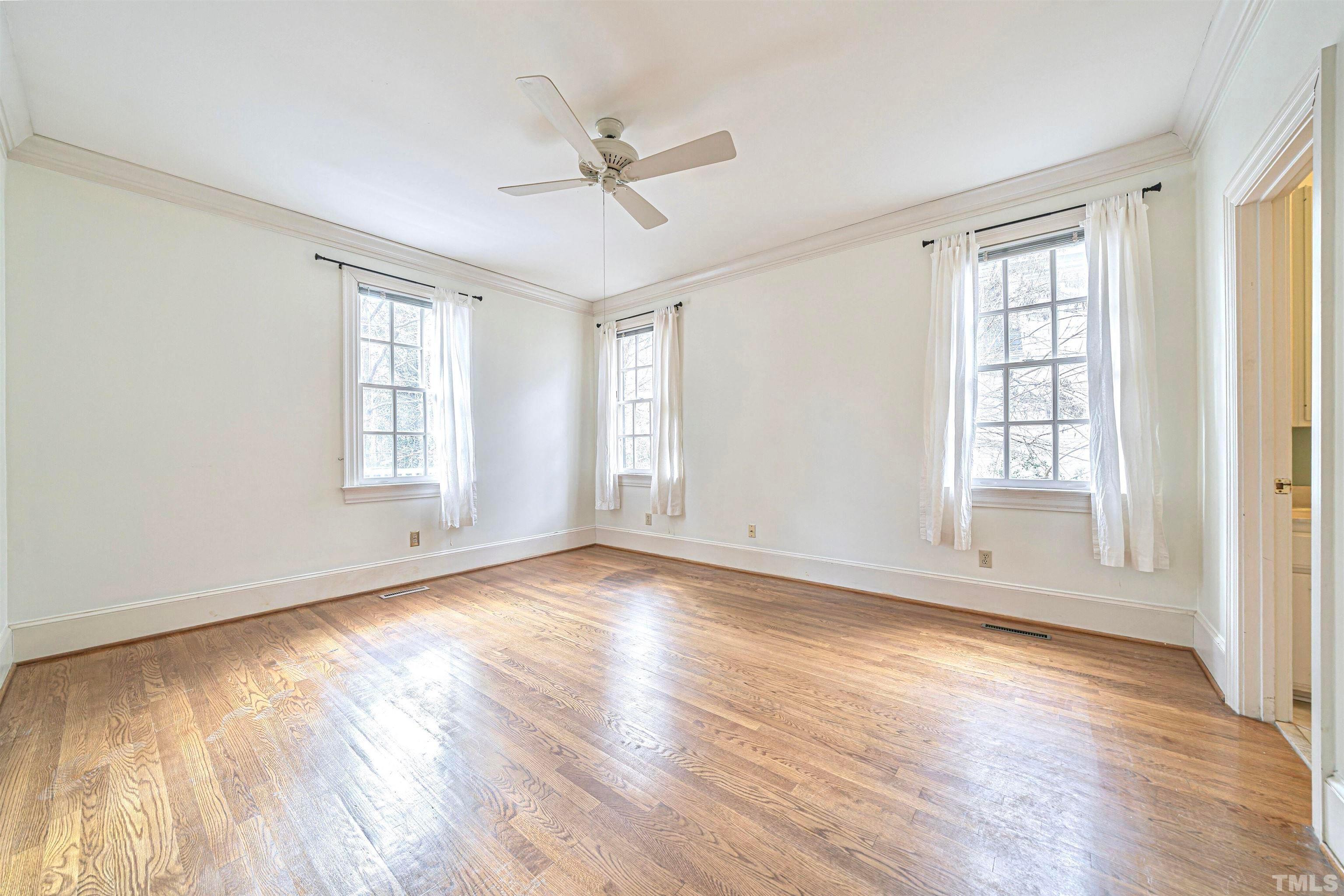 709 Runnymede Road Raleigh, NC 27607 - Photo 25 of 50 an empty room with wooden floor fan and windows