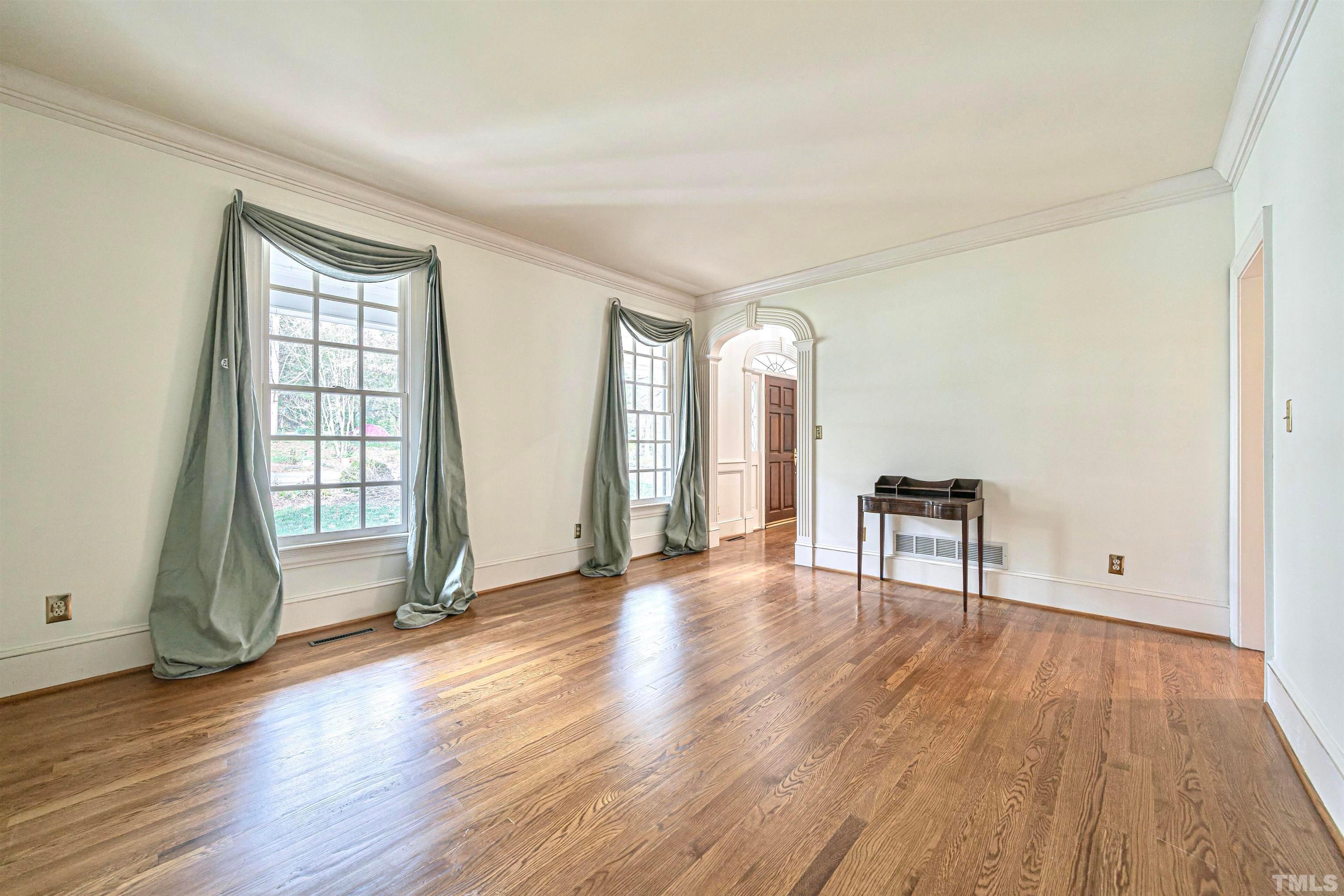 709 Runnymede Road Raleigh, NC 27607 - Photo 8 of 50 an empty room with wooden floor and windows
