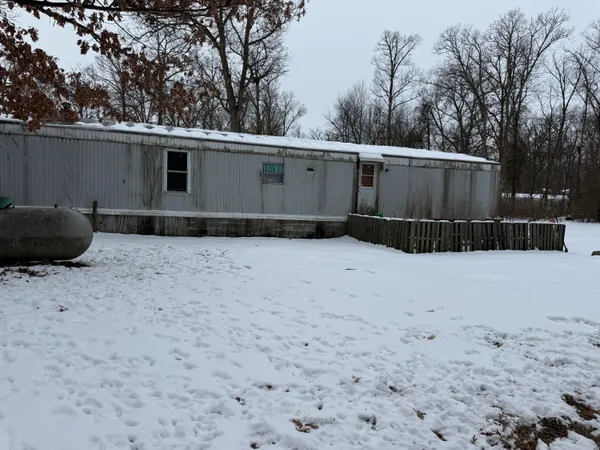 a backyard of a house with garage and furniture