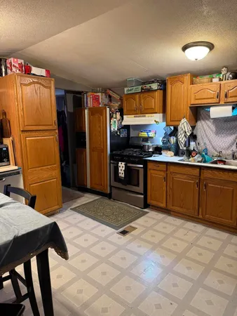 a kitchen with stainless steel appliances granite countertop a refrigerator a sink dishwasher and a stove with wooden floor
