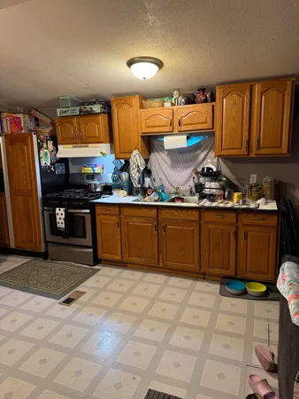 a kitchen with stainless steel appliances granite countertop a stove a sink and a refrigerator