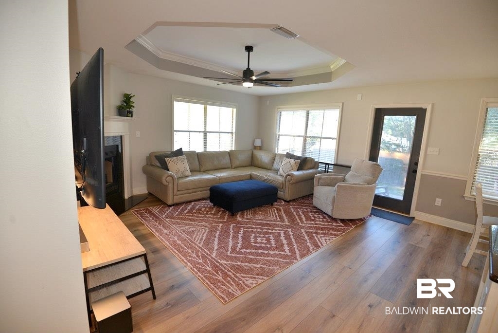 11201 Herschel Loop Daphne, AL 36526 - Photo 3 of 32 Living room featuring crown molding, wood-type flooring, a tray ceiling, and ceiling fan