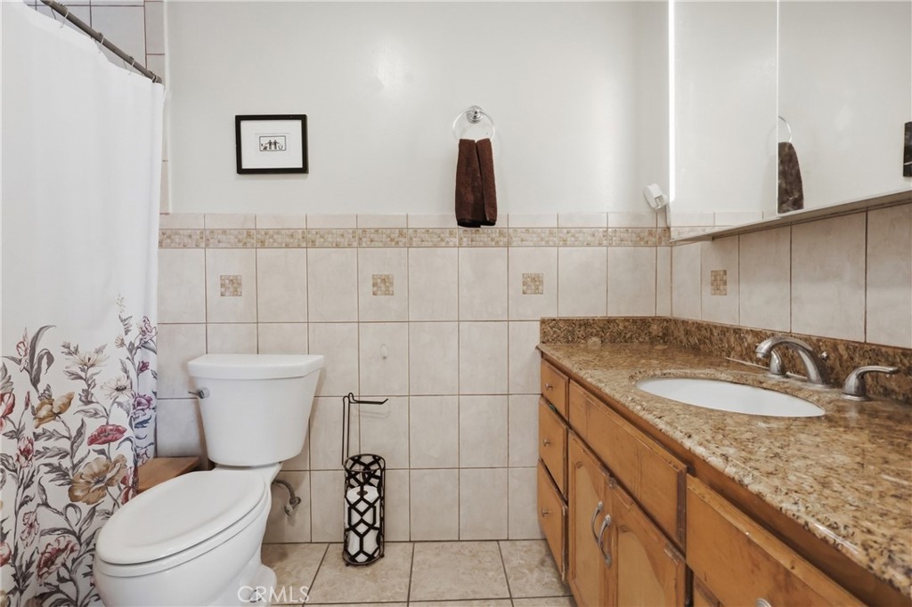 440 West Cherry Street Compton, CA 90222 - Photo 12 of 28 a bathroom with a granite countertop toilet sink and mirror