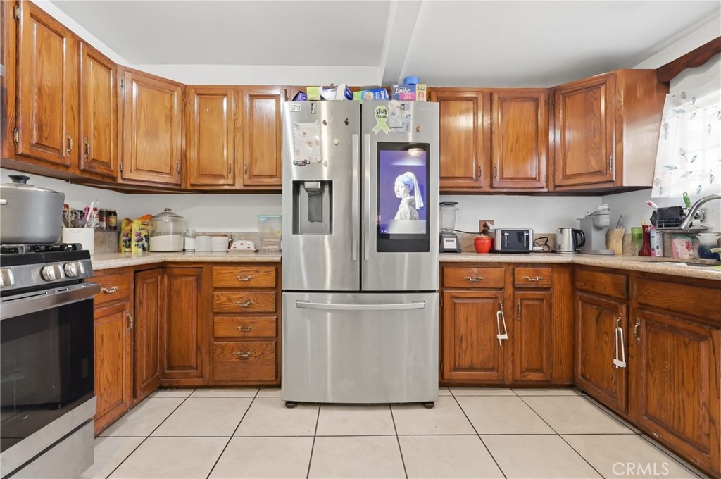 440 West Cherry Street Compton, CA 90222 - Photo 15 of 28 a kitchen with stainless steel appliances granite countertop a refrigerator and a stove top oven