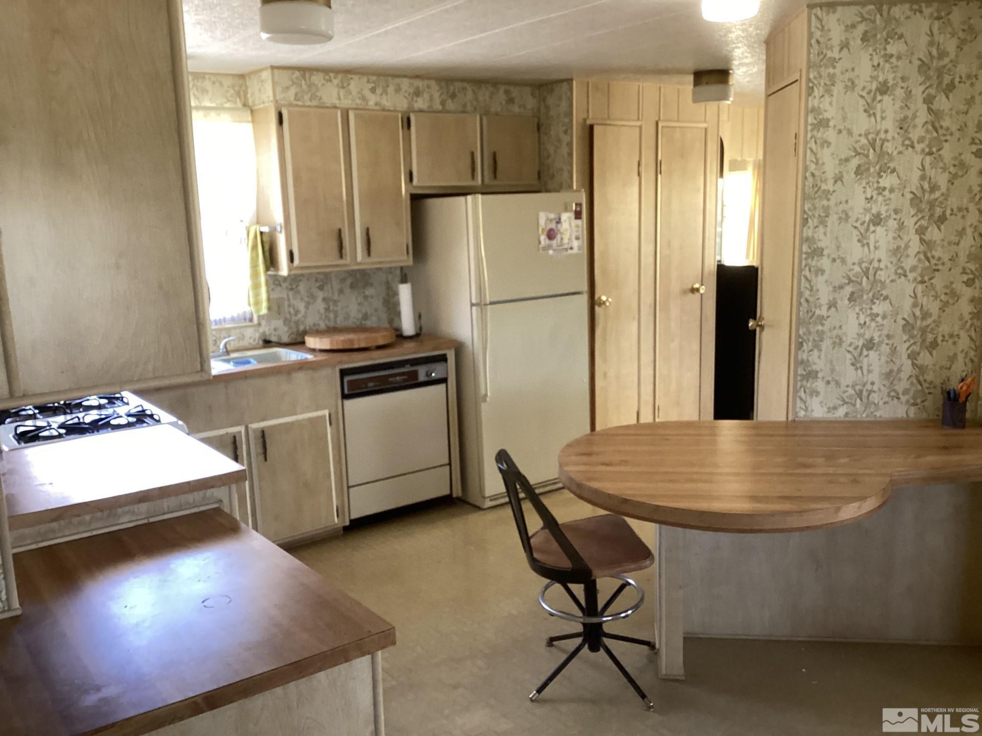 217 Territory Road Dayton, NV 89403 - Photo 7 of 15 a kitchen with stainless steel appliances granite countertop a stove a refrigerator and a dining table