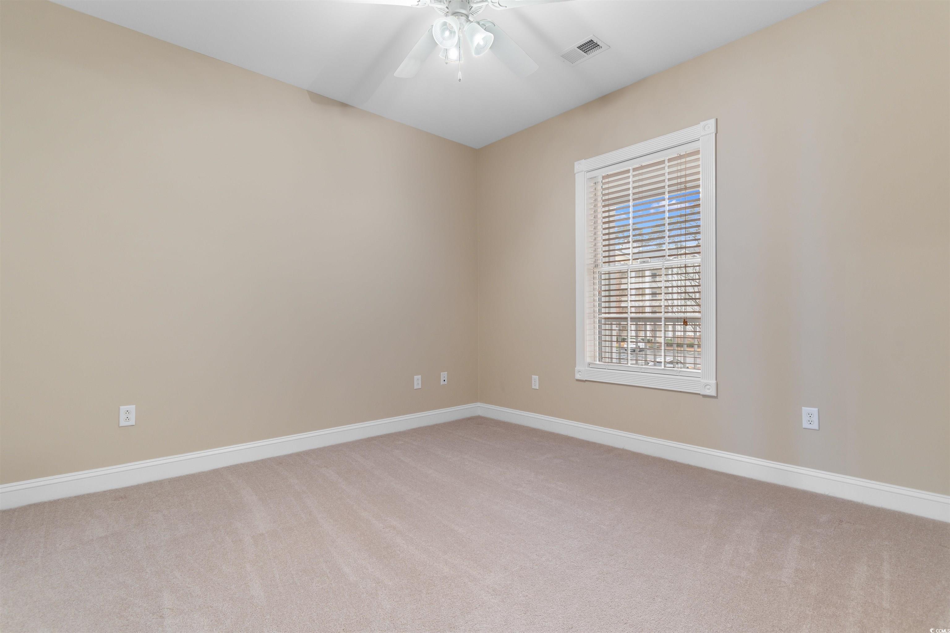 4875 Luster Leaf Circle, Unit 202 Myrtle Beach, SC 29577 - Photo 22 of 40 Empty room with a ceiling fan, light colored carpe