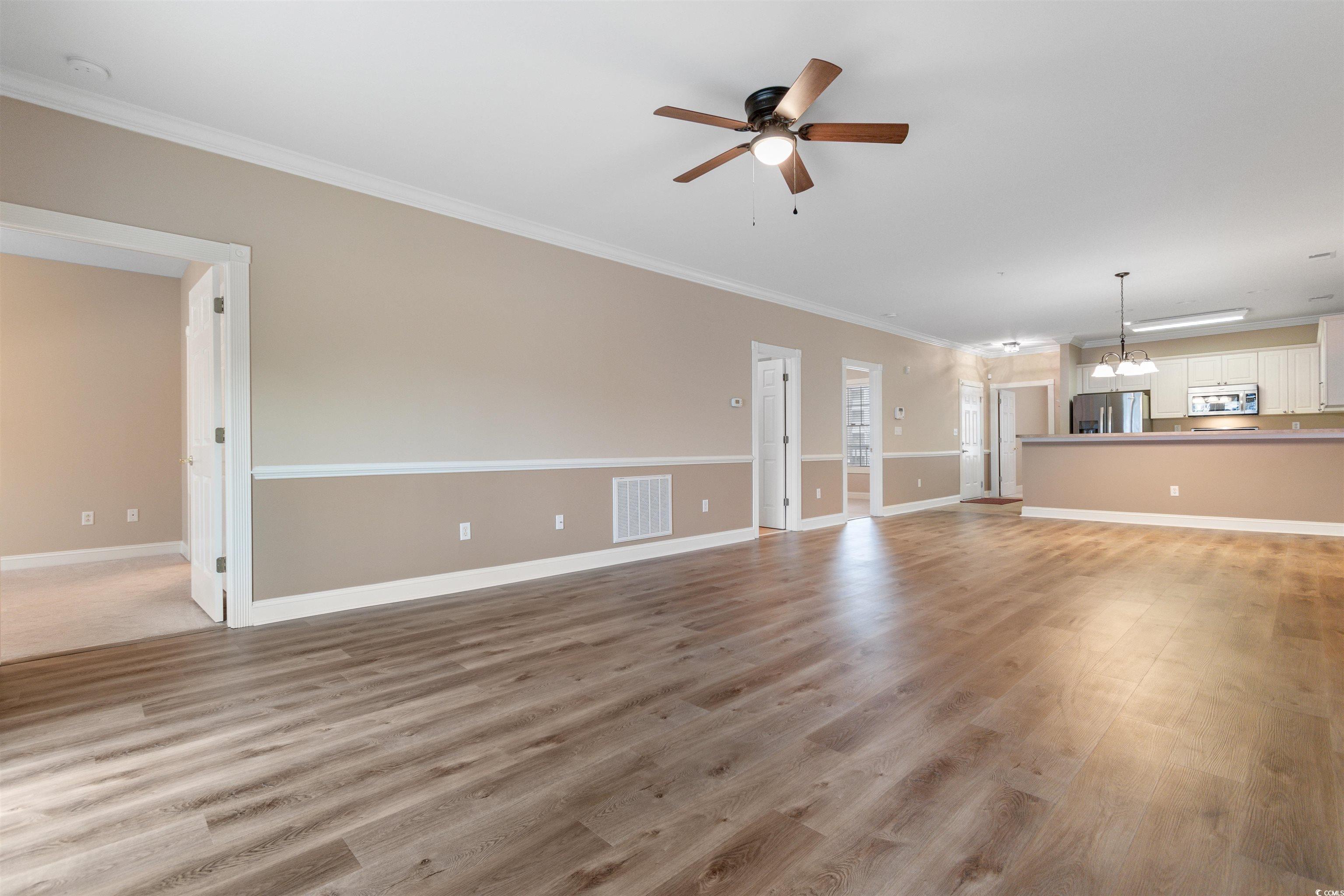4875 Luster Leaf Circle, Unit 202 Myrtle Beach, SC 29577 - Photo 10 of 40 Unfurnished living room featuring ornamental moldi