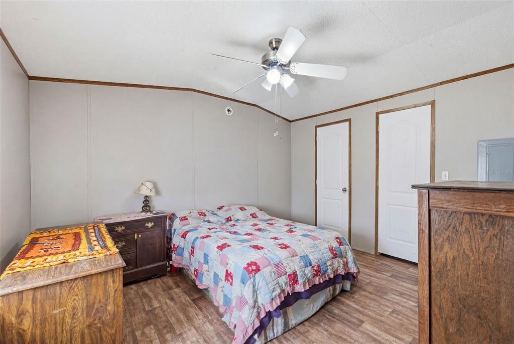 10501 East Patience Lane Inverness, FL 34450 - Photo 13 of 37 a bedroom with a bed and a chandelier