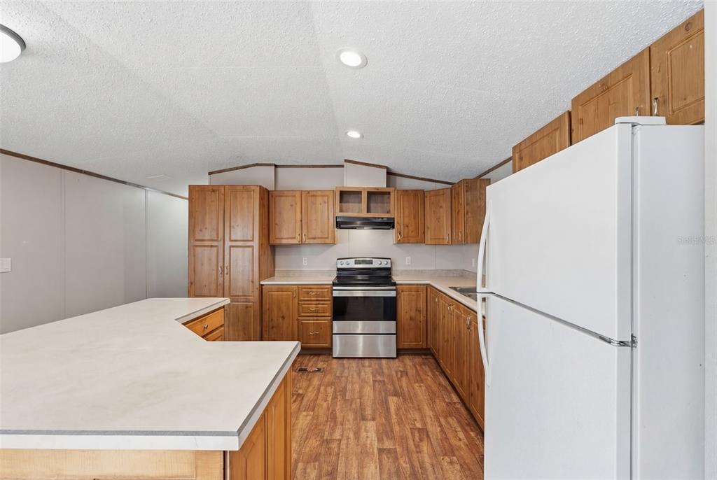 10501 East Patience Lane Inverness, FL 34450 - Photo 31 of 37 a kitchen with stainless steel appliances a refrigerator sink and stove