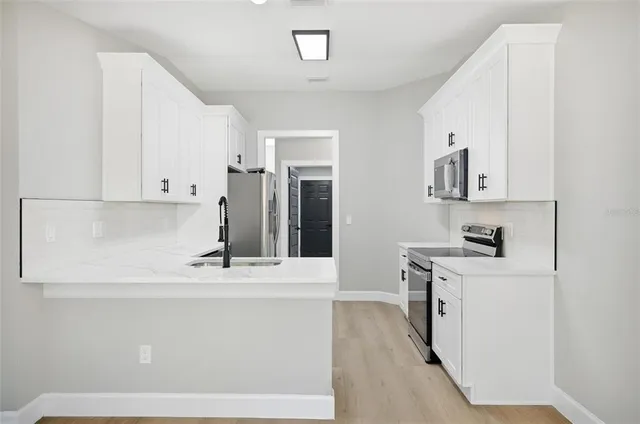 a view of kitchen with sink and refrigerator