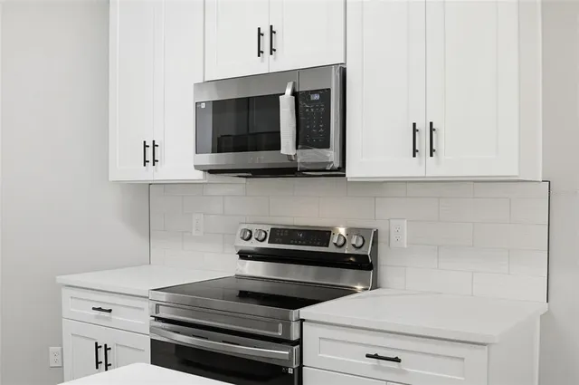 an empty room with wooden floor ceiling fan and windows