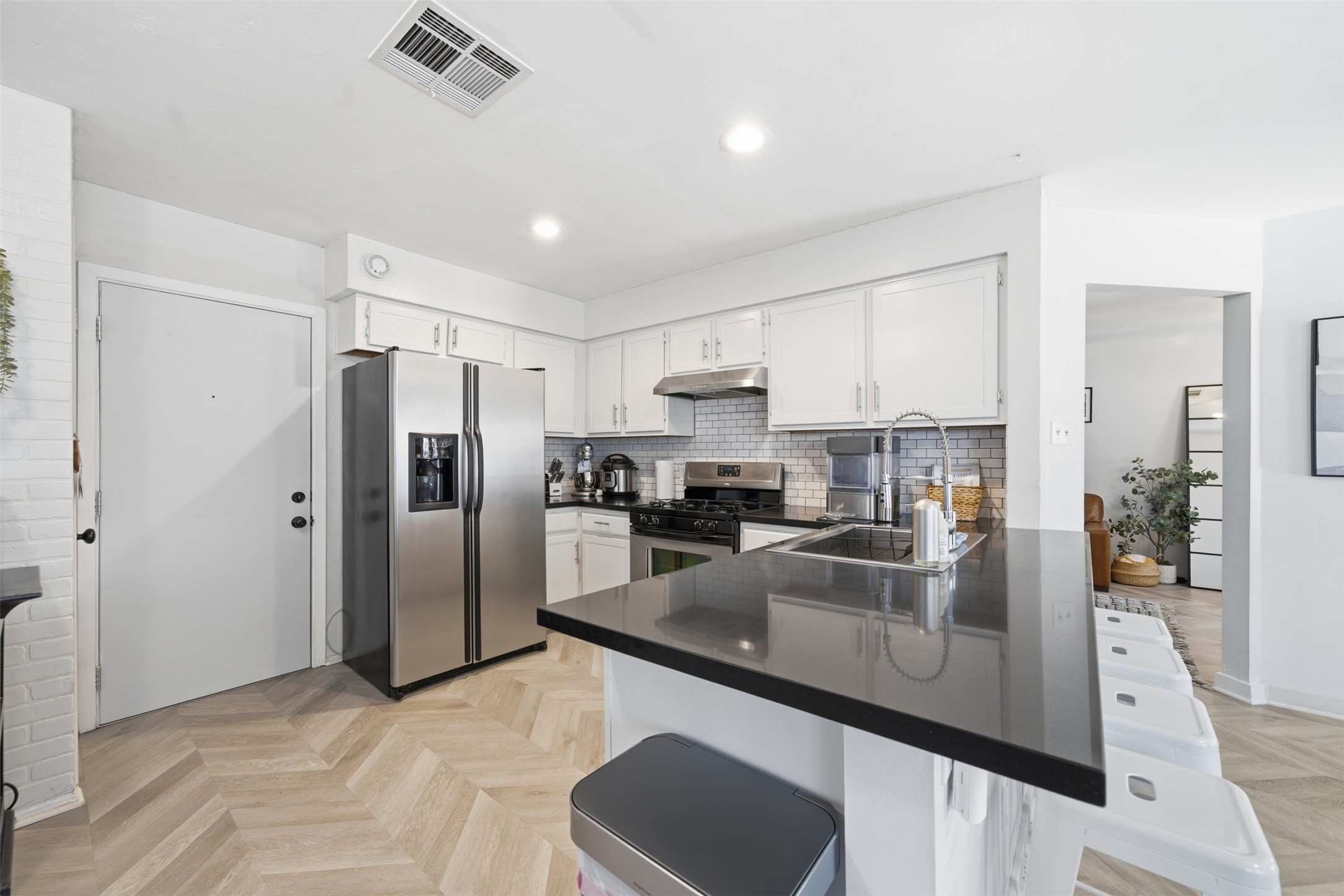 12906 Humphrey Drive Austin, TX 78729 - Photo 12 of 40 a kitchen with stainless steel appliances granite countertop a refrigerator a sink a stove a oven and white cabinets with wooden floor