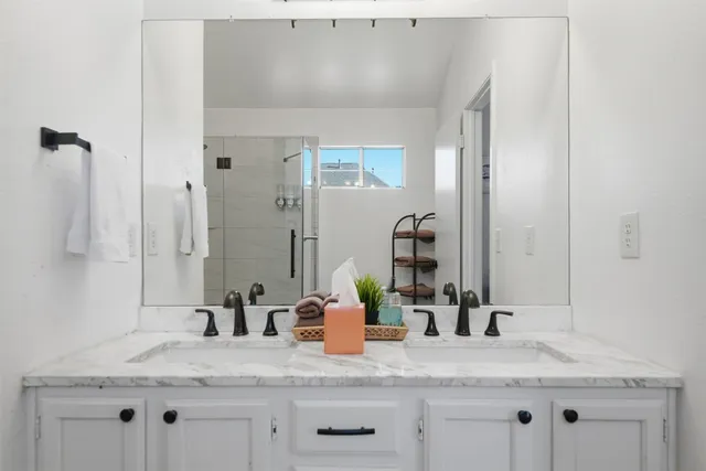 a bathroom with a granite countertop sink and a mirror