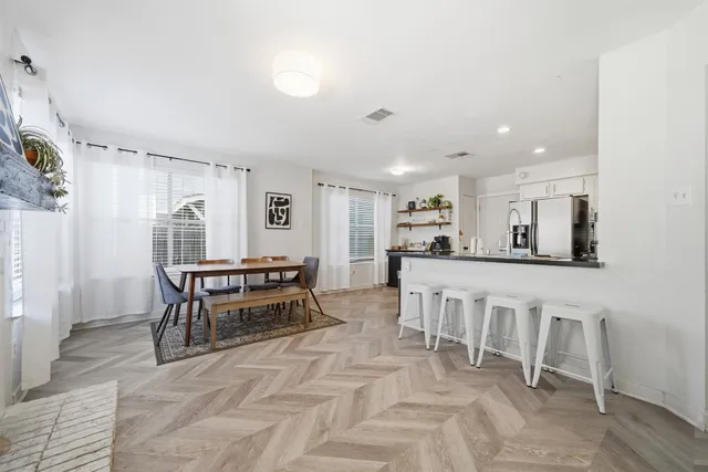 a kitchen with white cabinets and chairs