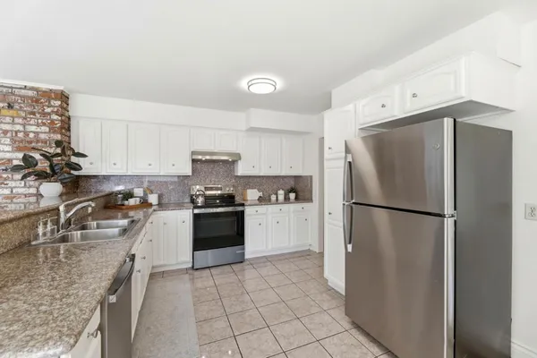 a kitchen with a refrigerator sink and cabinets