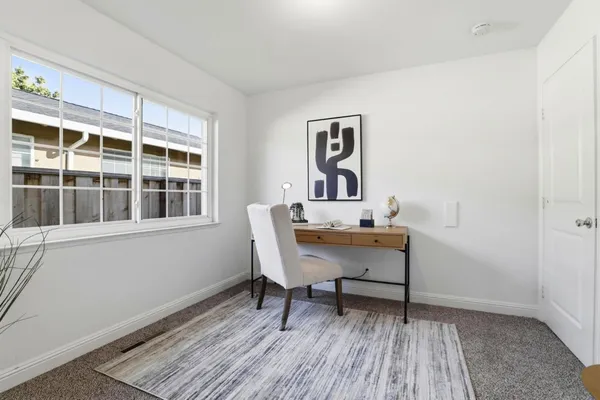 a view of a workspace with furniture window and wooden floor