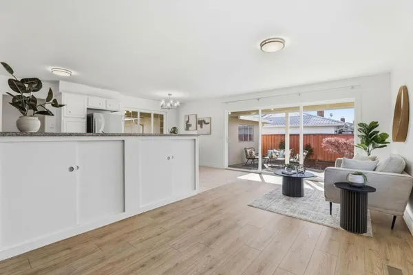 a view of kitchen with stainless steel appliances granite countertop a sink and wooden floor