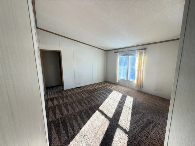 a view of a hallway with wooden floor and a living room