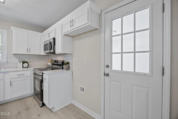 a kitchen with white cabinets and white appliances