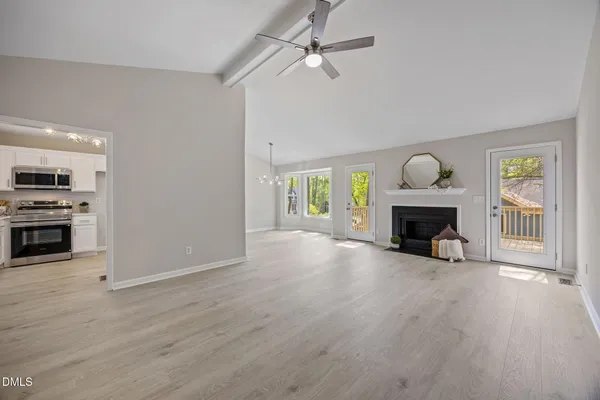 a view of an empty room with a fireplace and a window