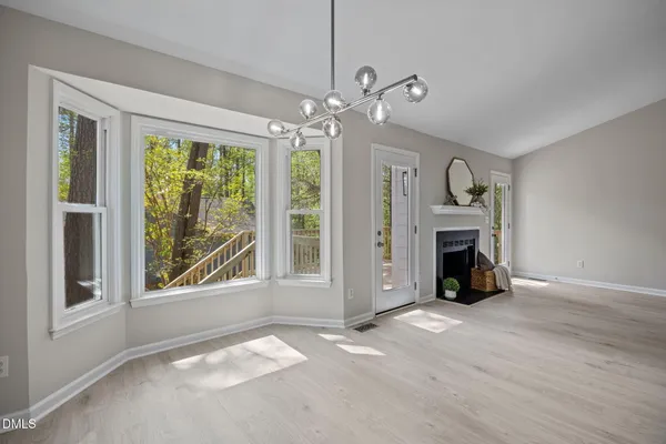 a view of an empty room with a fireplace and a window
