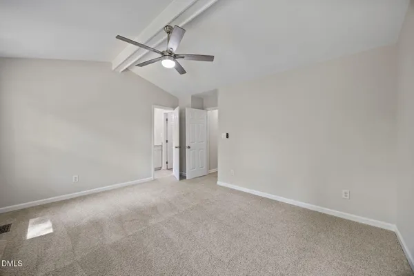 a view of an empty room and chandelier fan