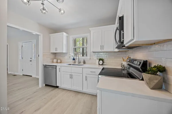 a kitchen with a sink a stove and cabinets