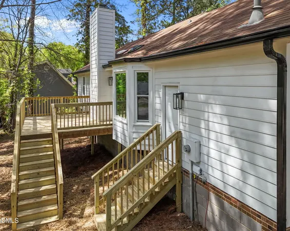 a view of a house with backyard and chairs