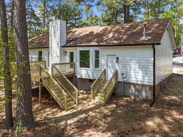 a view of backyard with deck and wooden fence