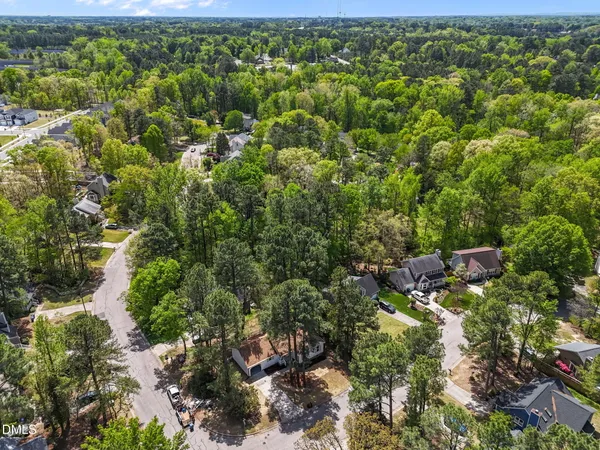 an aerial view of residential houses with outdoor space and trees