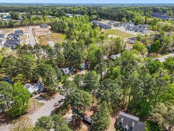 an aerial view of residential houses with outdoor space and trees