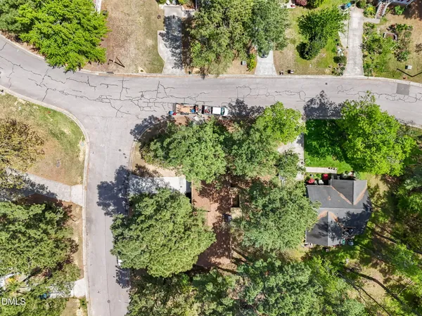 an aerial view of residential houses with outdoor space and trees