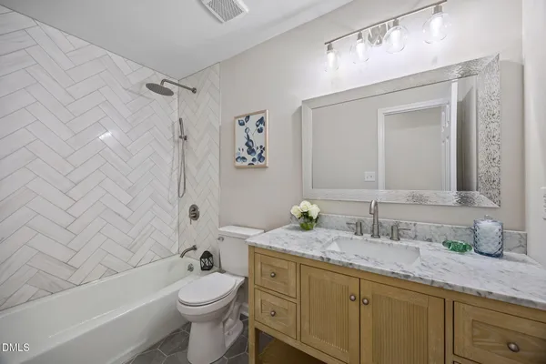 a bathroom with a granite countertop toilet a sink and bathtub