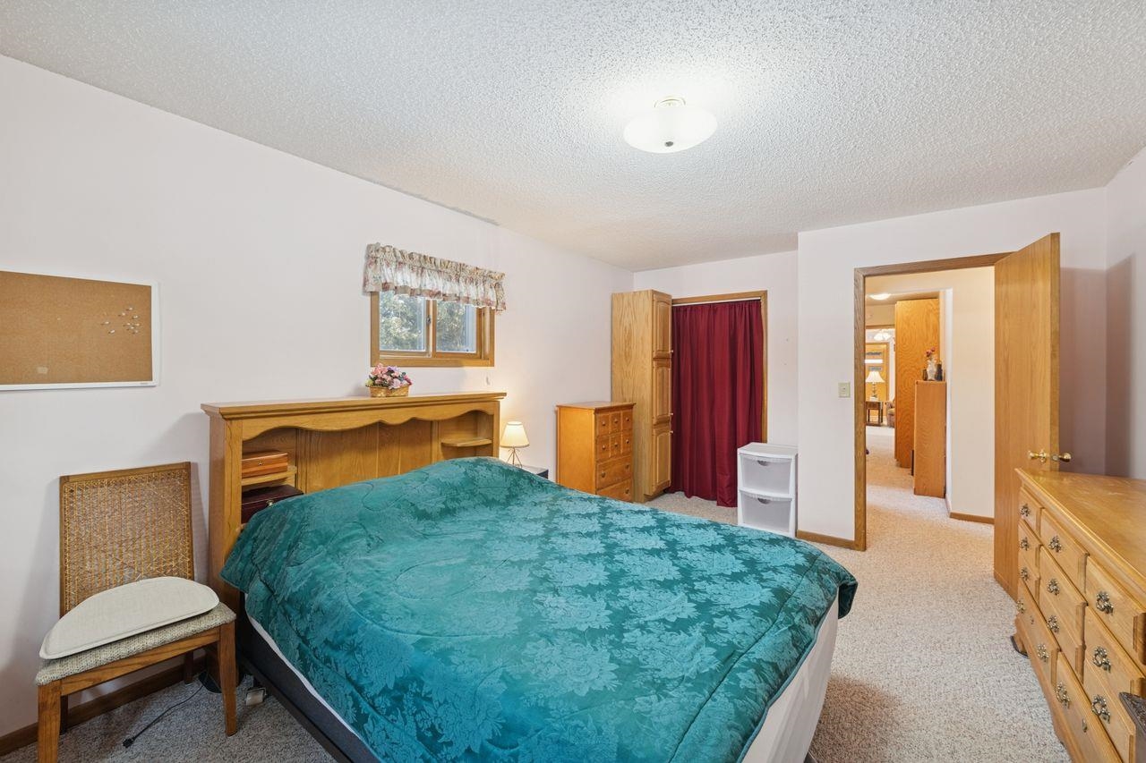 65915 Selke Road Mason, WI 54856 - Photo 13 of 33 Bedroom with light colored carpet and a textured ceiling