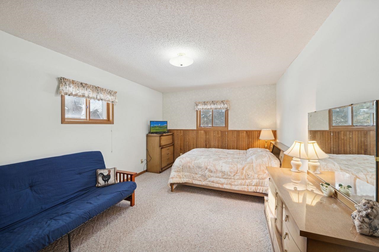 65915 Selke Road Mason, WI 54856 - Photo 14 of 33 Carpeted bedroom with a wainscoted wall, wood walls, and a textured ceiling