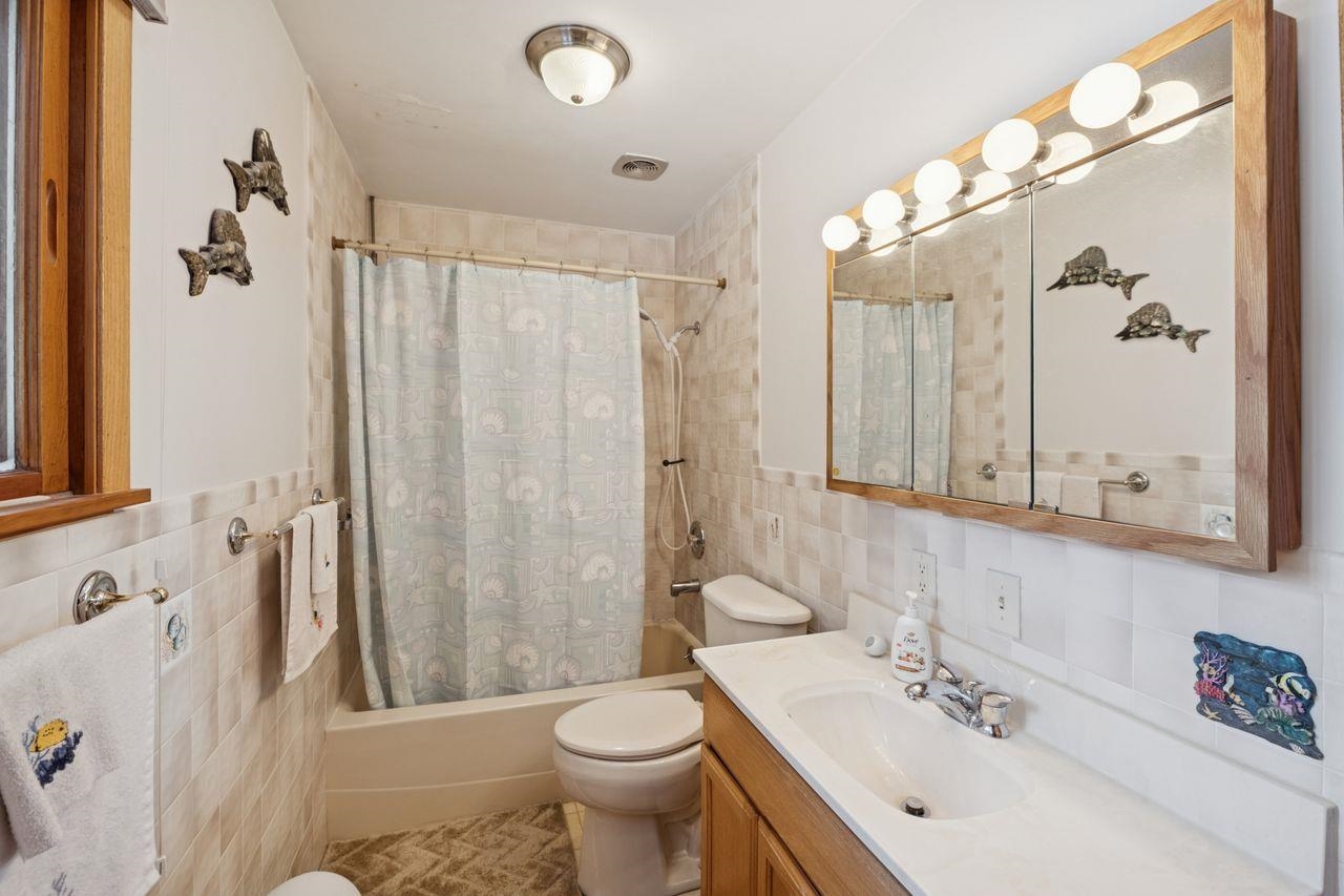 65915 Selke Road Mason, WI 54856 - Photo 16 of 33 Bathroom with tile walls, shower / bath combo, and vanity