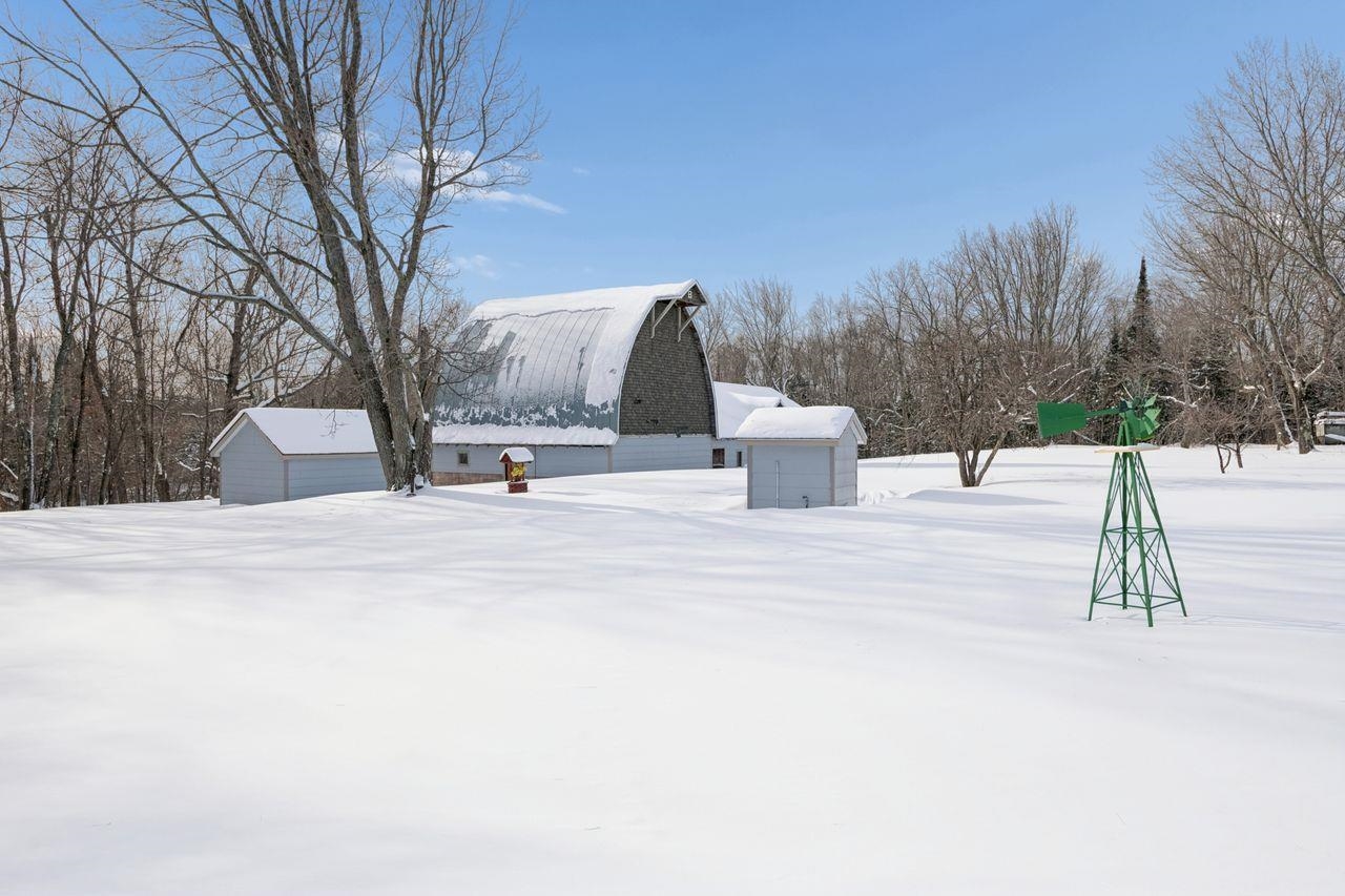 65915 Selke Road Mason, WI 54856 - Photo 28 of 33 Snowy yard featuring an outbuilding, a barn, and view of wooded area