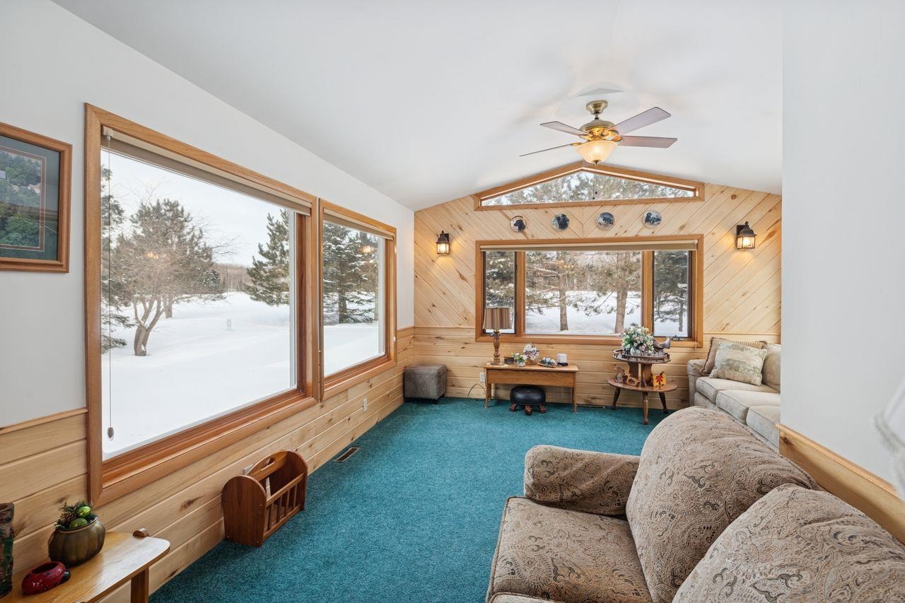 65915 Selke Road Mason, WI 54856 - Photo 3 of 33 Living area with wood walls, carpet, ceiling fan, and lofted ceiling